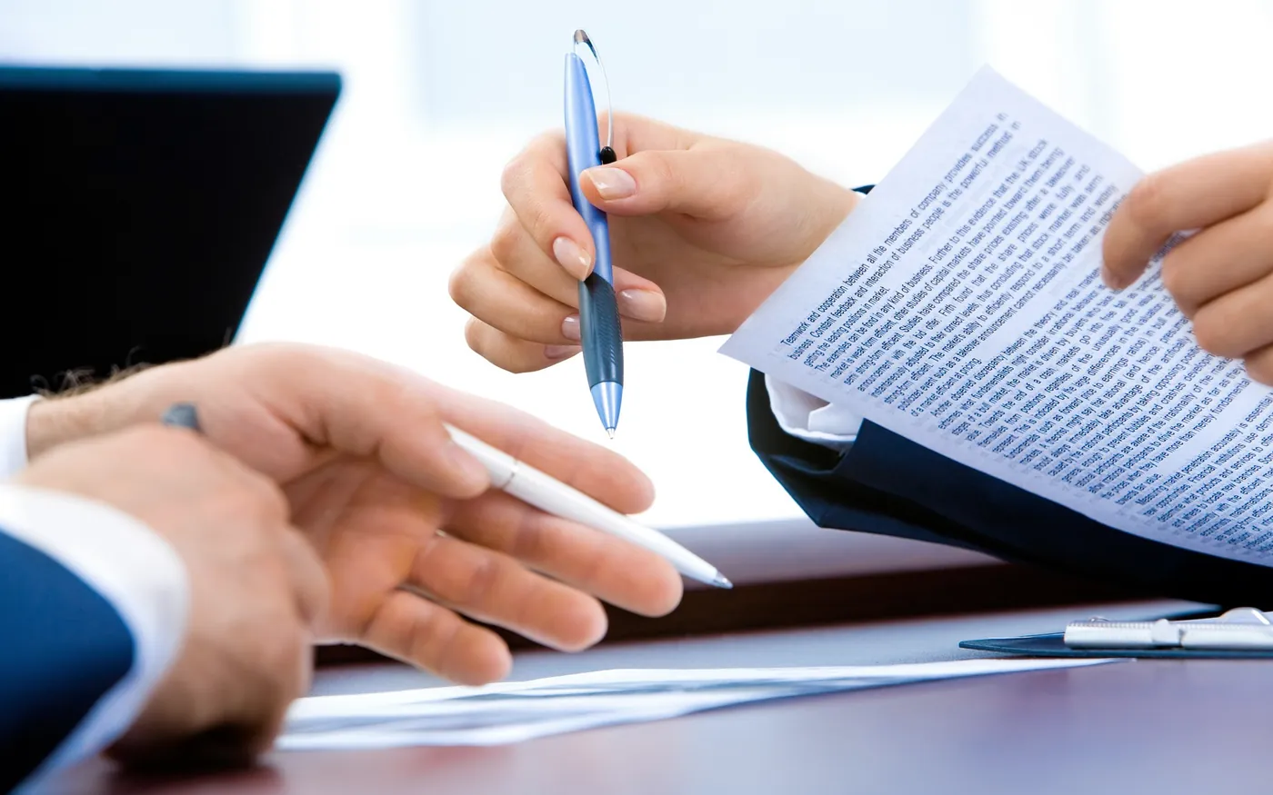 Duas pessoas analisando um documento sobre a mesa